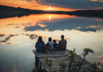 A family sitting on a bridge.