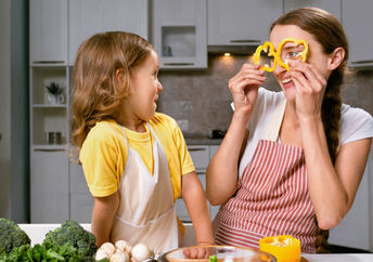 A mother and daughter have fun preparing vegetables, an important food in a psychobiotic diet.