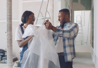 Happy couple having fun with bubble wrap.