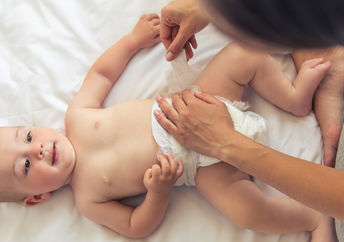 Mother diapering her baby.