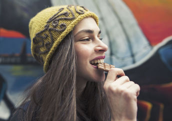 Woman enjoying a chocolate bar.