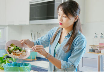 Korean woman saving food scraps.