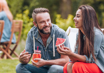Enjoying watermelon at a summer barbeque.