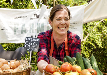 Women selling produce at a famers market.