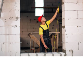 Construction worker using concrete blocks.