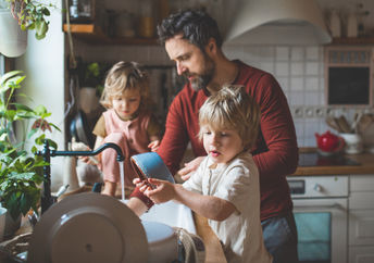 Father and sons washing dishes.