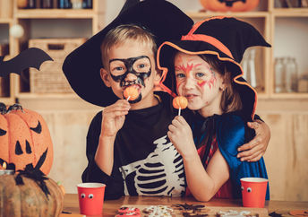 Costumed children enjoying festive foods.