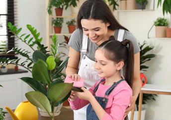 Mother and daughter taking care of houseplants.