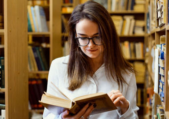 A woman looking words up in a dictionary.