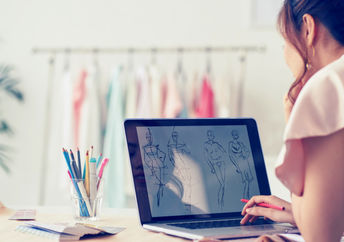 Fashion designer drawing sketches for new collection.