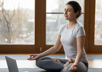 Woman beginning a series of yoga poses to help her get over a cold.