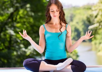 Doing yoga in a park.