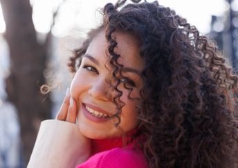 Smiling, young Gen Z woman.