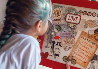 A vision board idea for travel to France is made by a woman who wants to manifest travel.