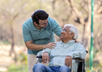 A young man helping a senior.