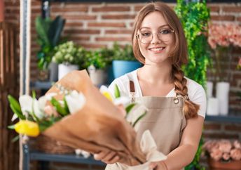 A young florist smiles for the camera.
