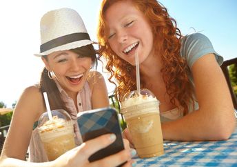 Two Gen Z friends enjoying iced coffee.