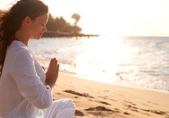 Practicing meditation on a beach.