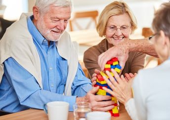 Seniors with dementia interacting at a memory cafe.