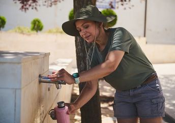 A woman refilling her reusable water bottle.