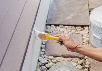 A person paints a structure.