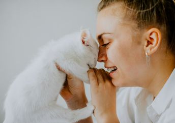 A woman holds a kitten.