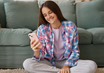 A teenage girl using an AI companion on her phone.