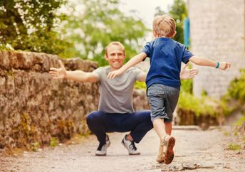 A boy runs into his father’s arms.