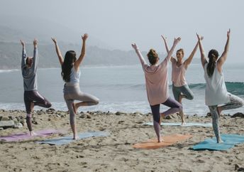 Women doing yoga on the beach.