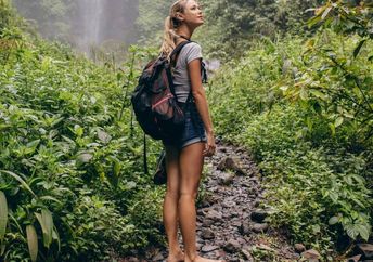 A woman walking barefoot in the forest.