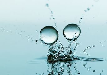 Gel balls falling against a blue background.