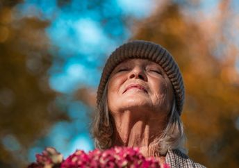 A senior woman expressing gratitude for all she has.