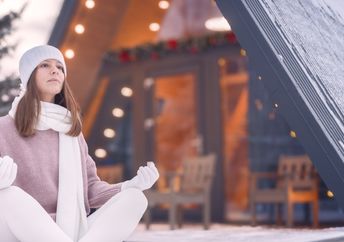 Woman meditating outside in winter.