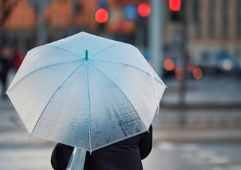 Using an old-fashioned umbrella on a rainy day.