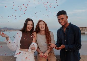 Cheerful young friends photographed by the sea, enjoying life.