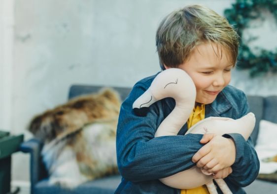 A boy hugs a plush toy.