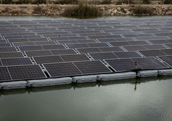 A solar panel system installed above a fish pond.