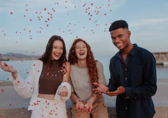 Cheerful young friends photographed by the sea, enjoying life.