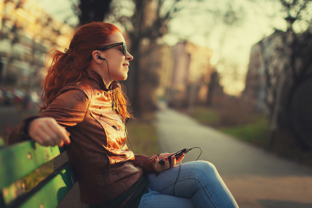 Woman listens to music on smartphone