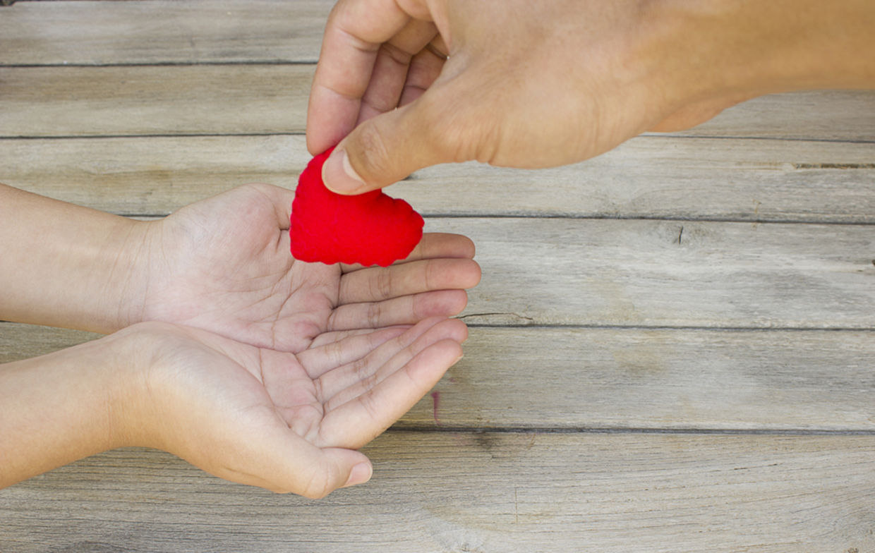 Hand handing over a heart