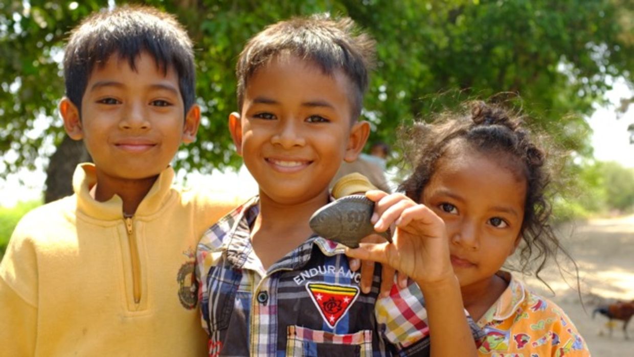 Children holding lucky iron fish