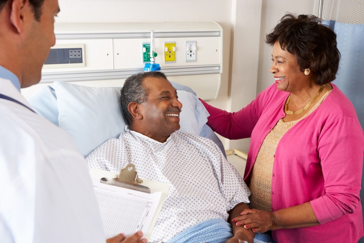 Doctor Talking To Senior Couple On Ward