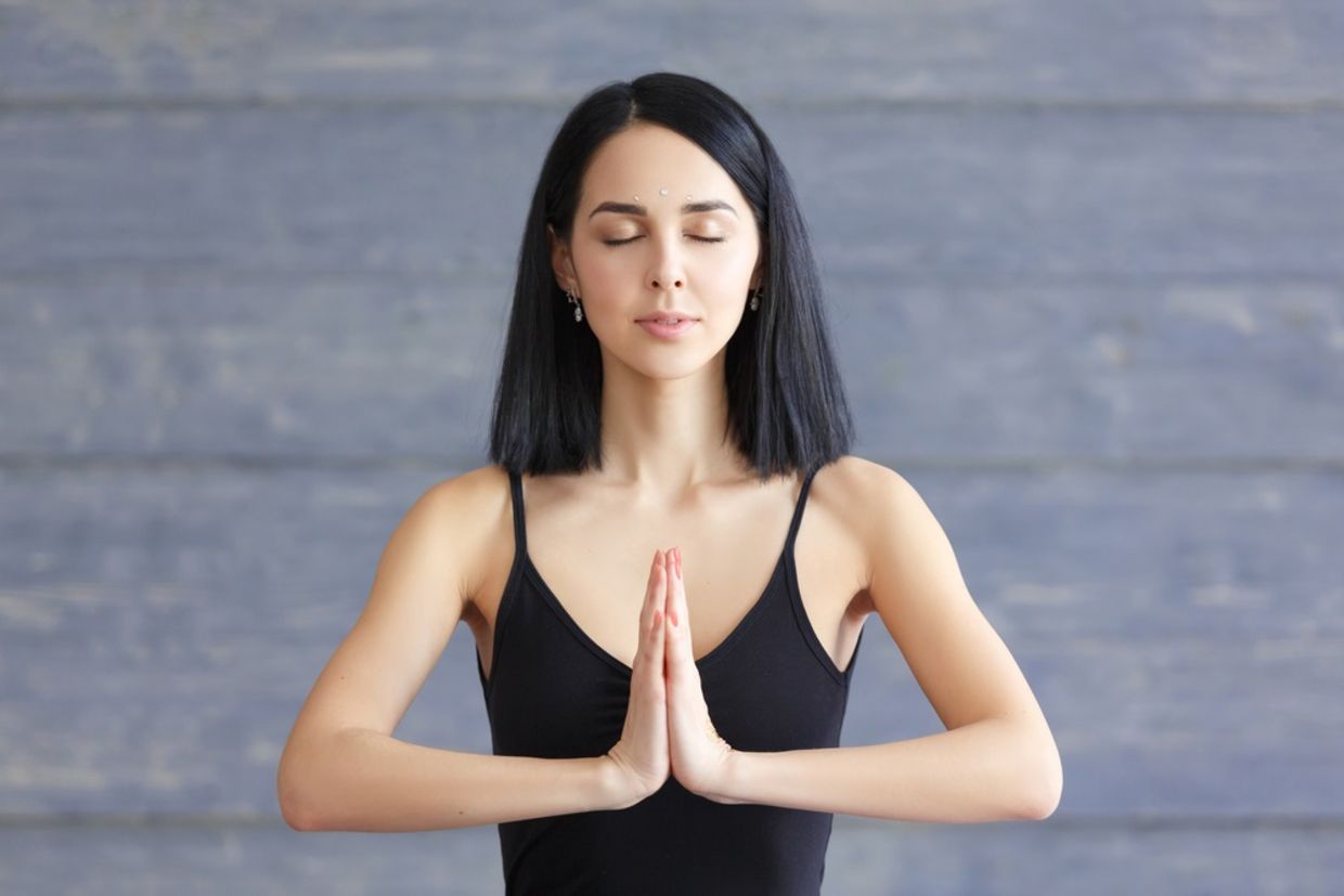 Portrait of smiling brunette young woman enjoying yoga.