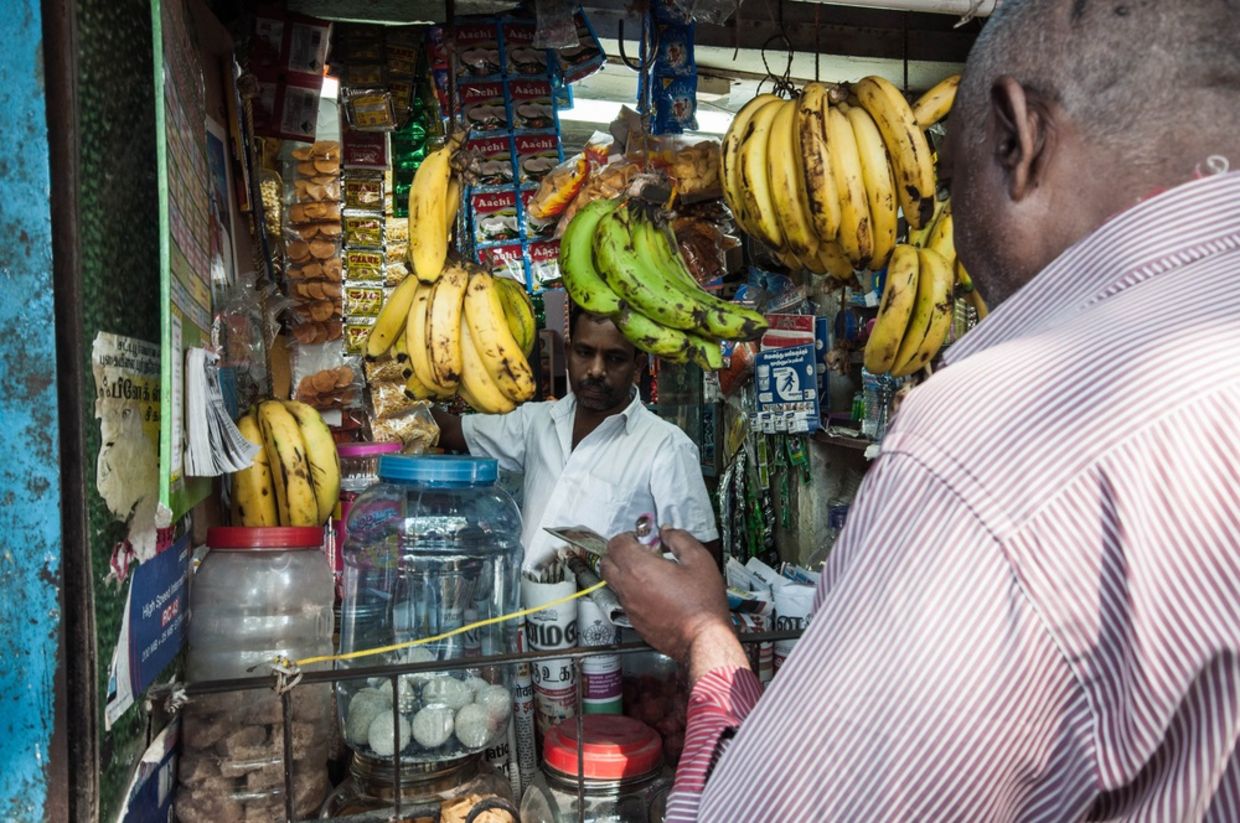 inside of local store. Indian trader in his shop on local market selling all kind of goods