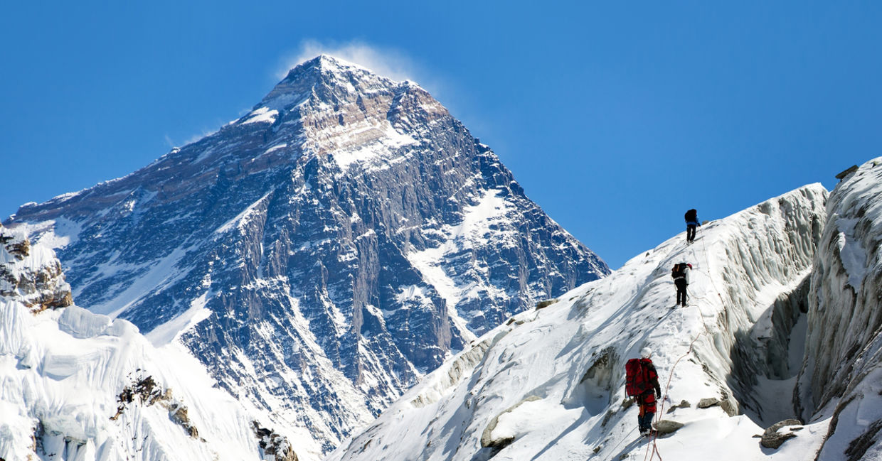 View of Everest from Gokyo valley with a group of climbers on a glacier on their way to Everest base camp