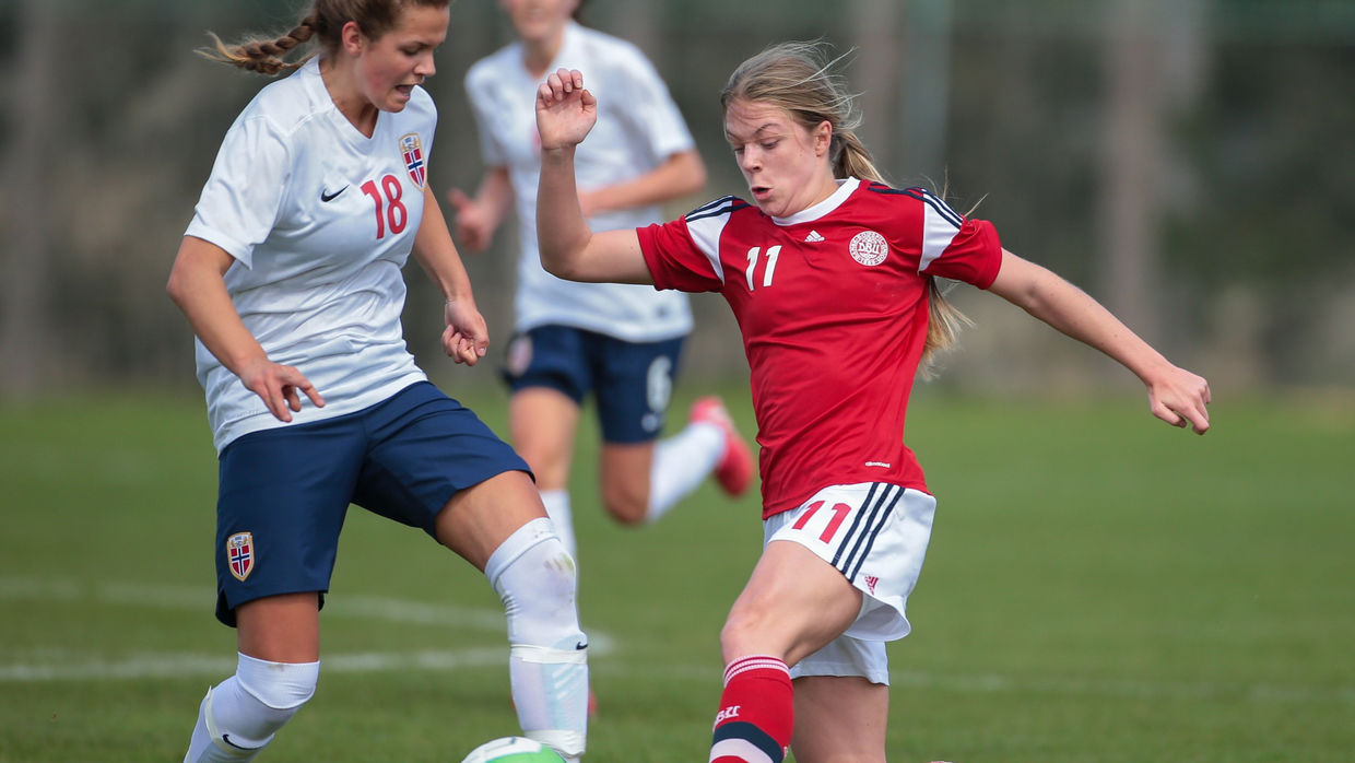 Andrea Norheim (#18 Norway) and Freja Kjaersig Sunesen (#11 Denmark) fight for the ball during a UEFA women's U17 qualifying game