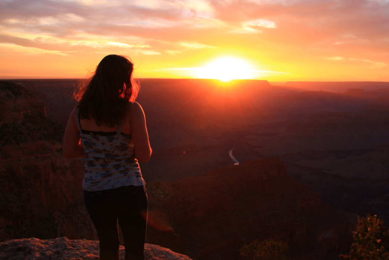 A woman looking in awe at a beautiful sunset