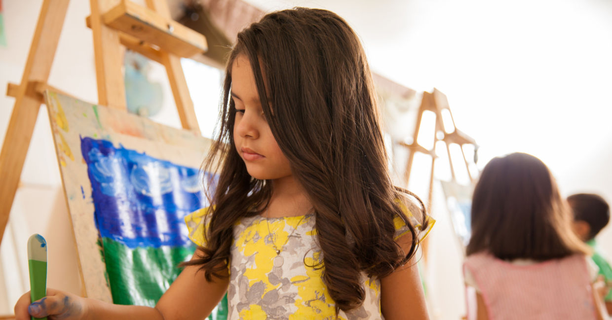 Little girl painting with bright colors