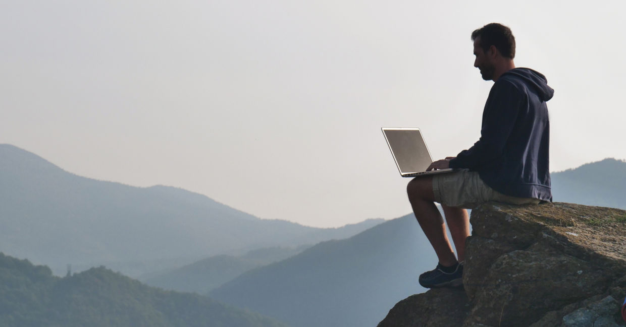 man working outdoors on laptop