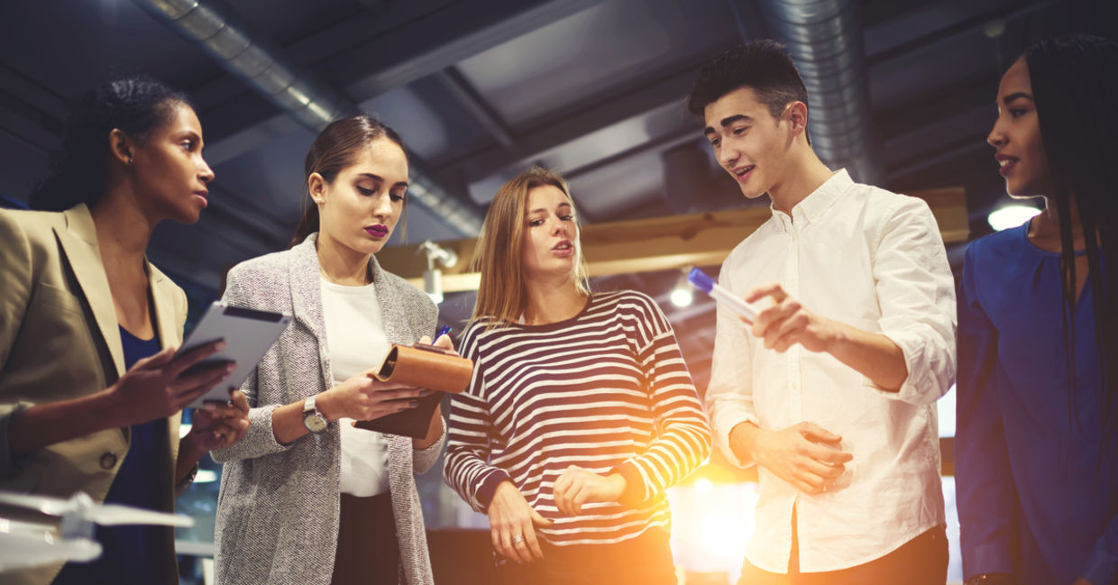 Crew of young architects brainstorming on morning meeting discussing new project concept